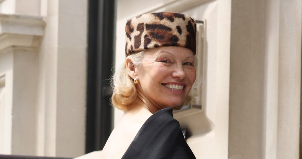 Pamela Anderson Channels Jackie Kennedy in Pillbox Hat & Backless Dress