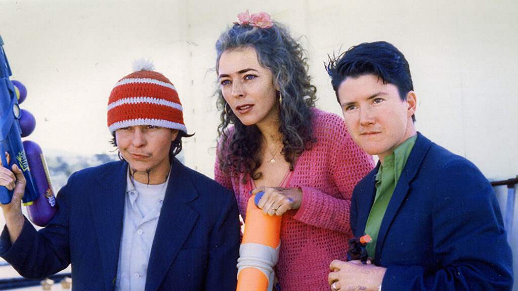Harry Dodge, Stanya Kahn, and Silas Howard standing together and looking out in the distance in a film still from By Hook or By Crook