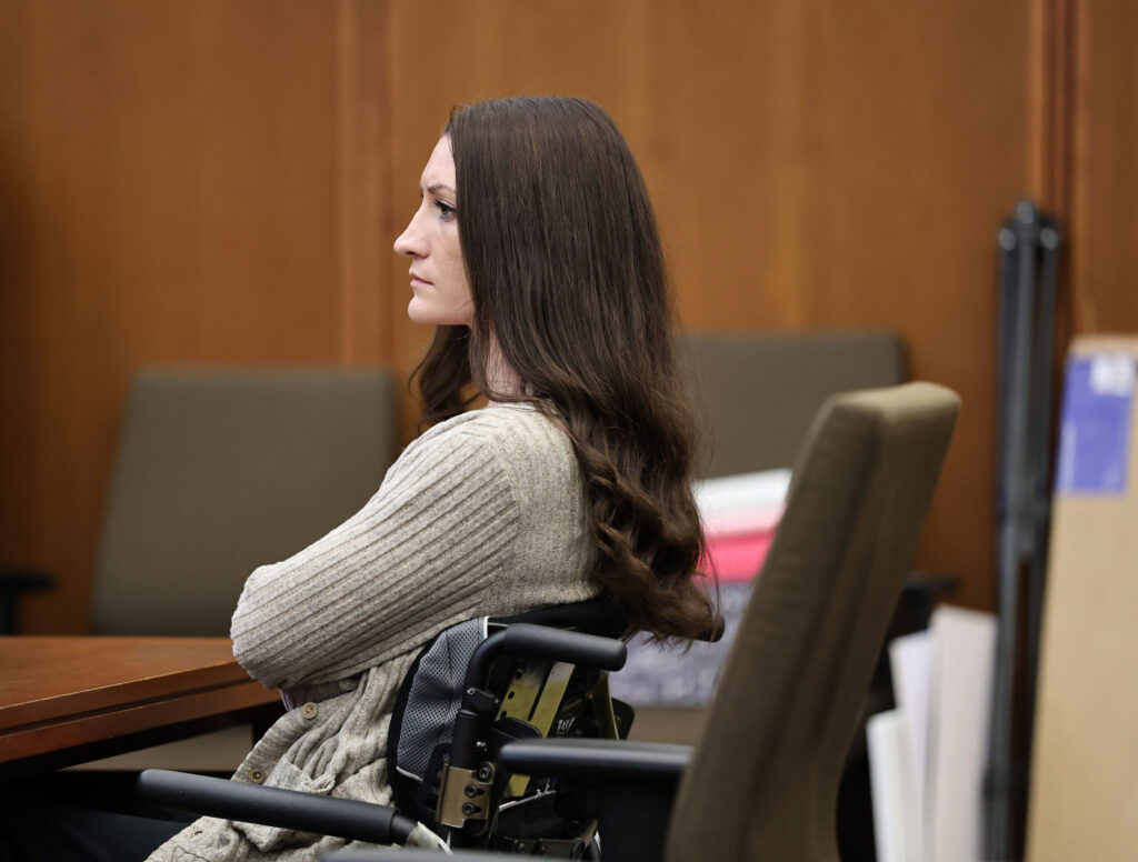 Lindsay Clancy sits in a wheelchair with her arms cross in a court room.