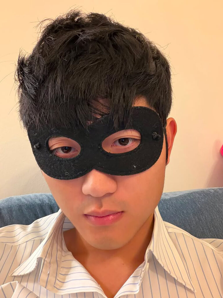 Charles Hsu with a black eye mask on
